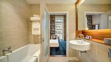 Un baño moderno con bañera, lavabo y espejo.