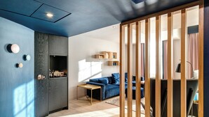 A modern living room with a blue accent wall, a wooden partition, and a sofa. - Apex Waterloo Place Hotel (Edinburgh)