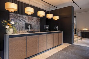 A reception desk with a modern design, featuring a dark wood finish and a large, decorative wall mural.