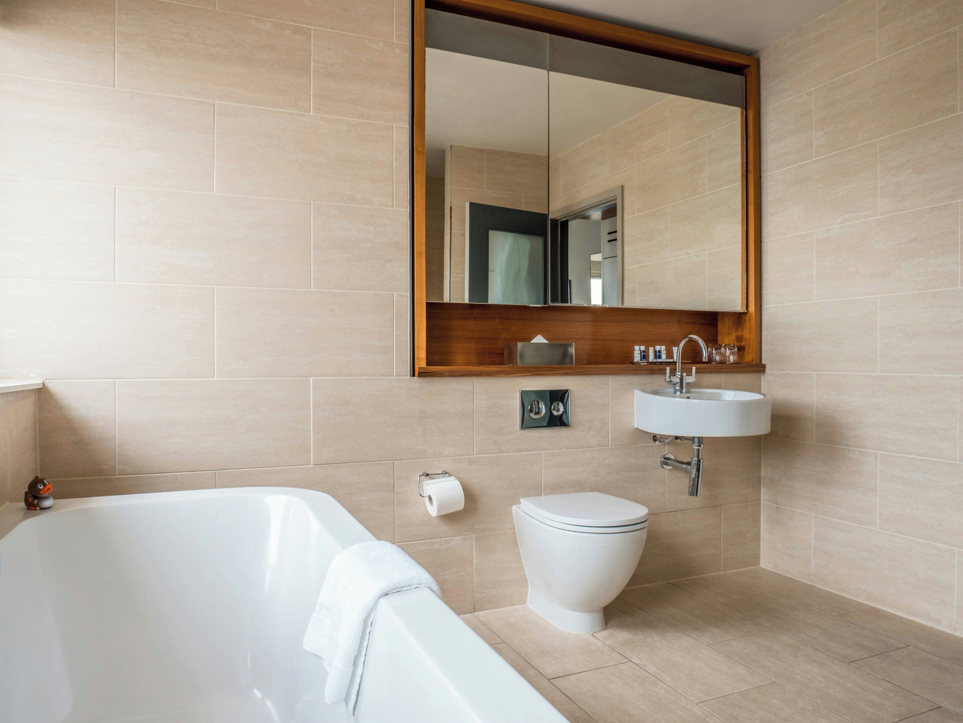 A modern bathroom with a bathtub, toilet, and sink.