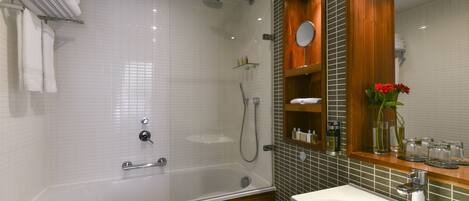 Une salle de bain moderne avec une douche à parois de verre, un lavabo blanc et un meuble-lavabo en bois.