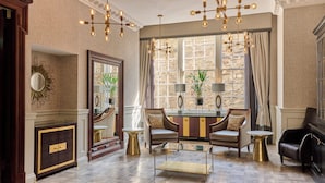 A spacious living room with a large mirror, a dining area with two chairs, and a coffee table. - Fraser Suites Edinburgh (Edinburgh)