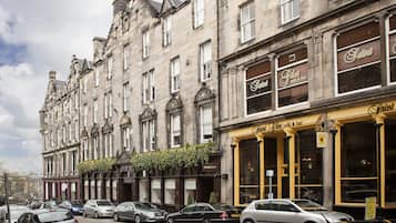 A historic building with multiple stories, featuring classic architectural details and a café/bar on the ground floor.