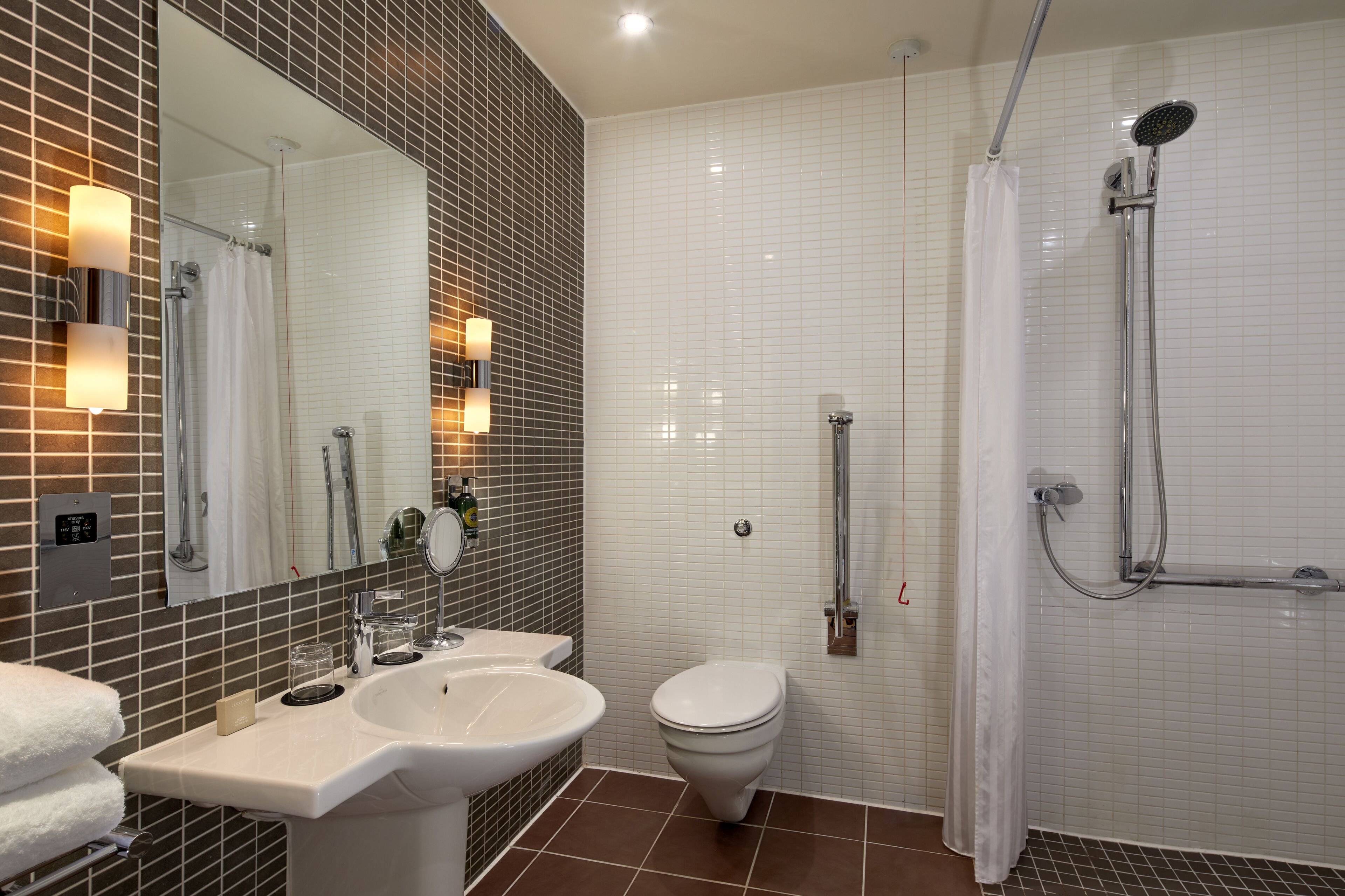 A modern bathroom with a sink, toilet, and shower.