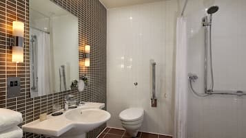 A modern bathroom with a sink, toilet, and shower.