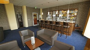 A bar area with multiple seating options, a bar counter, and a wine rack. - Hotel Royal International (Leipzig)