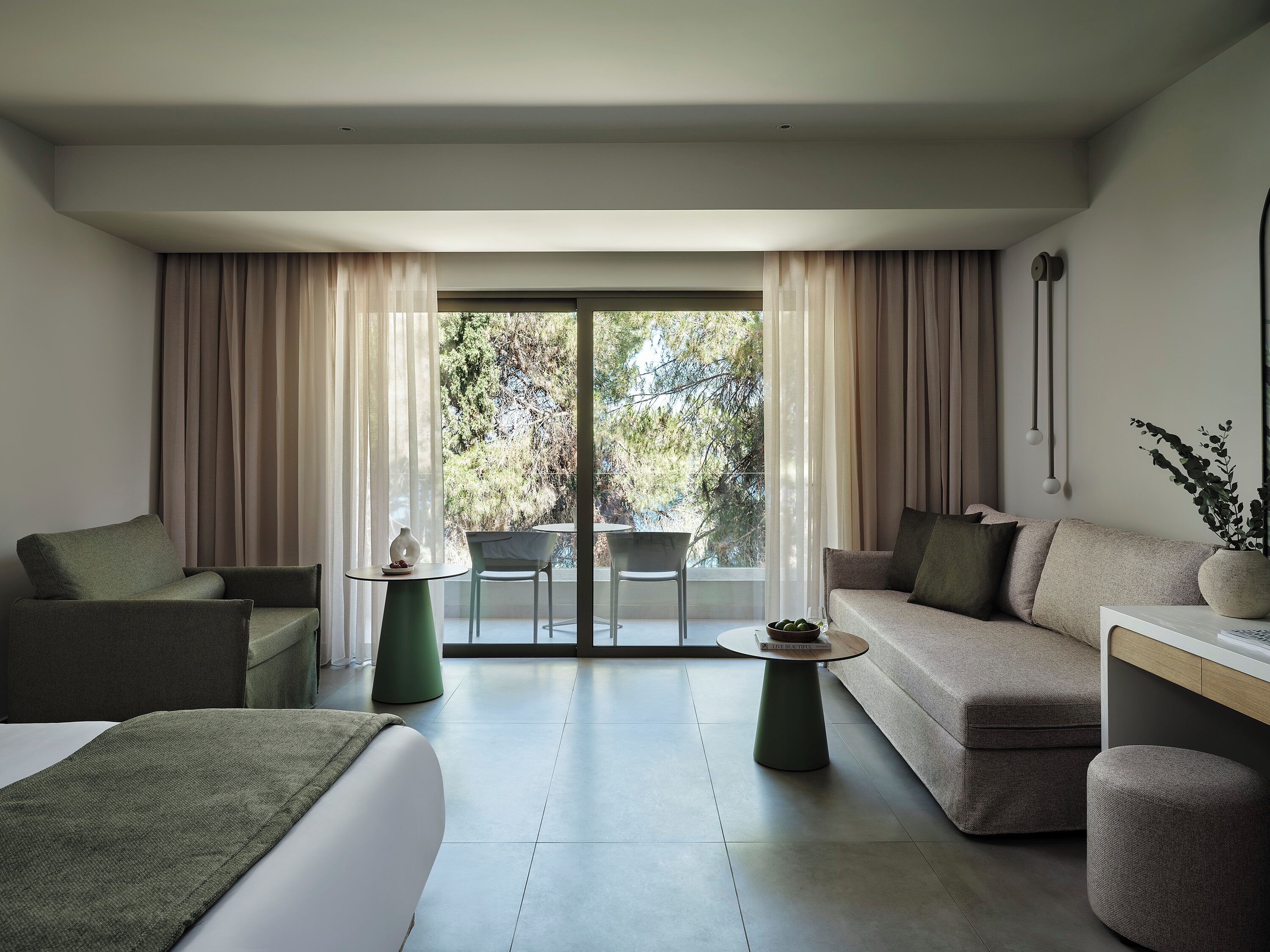Una sala moderna con un sofá, un sillón y una pequeña mesa con un florero.
