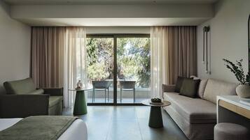A modern living room with a sofa, armchair, and a small table with a vase.