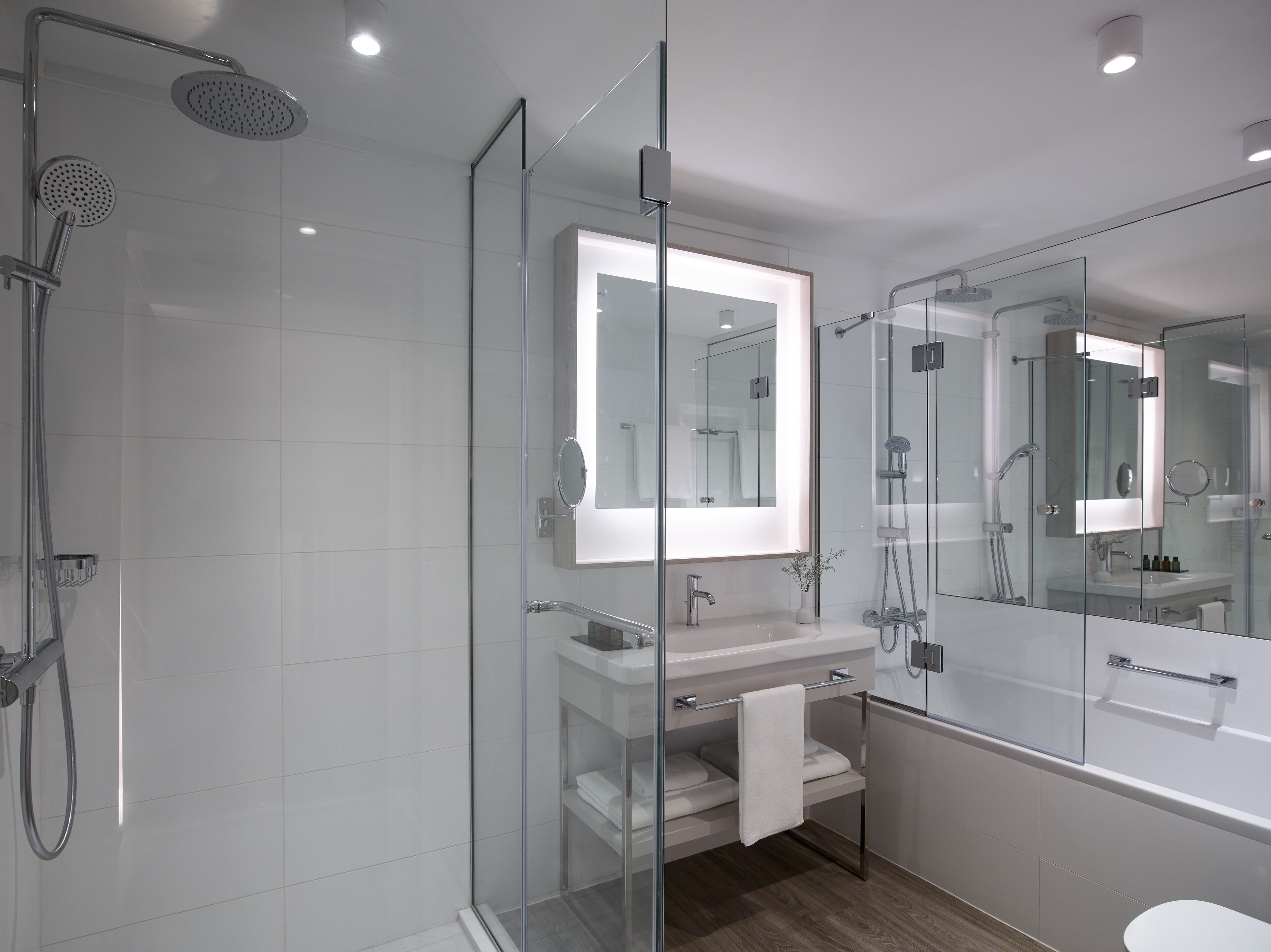 Une salle de bain moderne avec une douche à parois de verre, un meuble-lavabo avec un miroir et des toilettes.