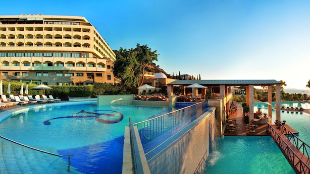 A resort with a large pool, lounge areas, and a building with balconies. - Amus Hotel & Spa (Rhodes)