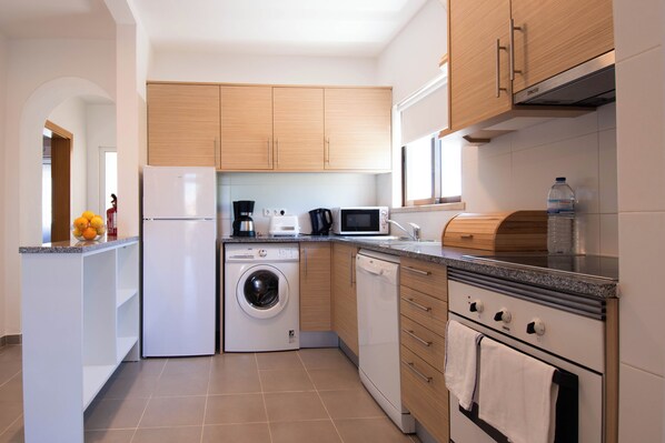 Una cocina moderna equipada con lavadora, microondas y horno.