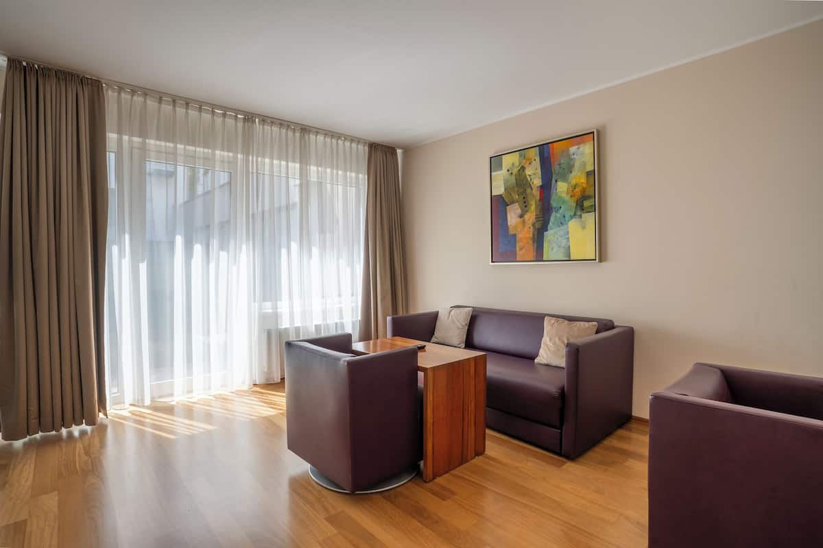 A modern living room with a sofa, two armchairs, and a coffee table.