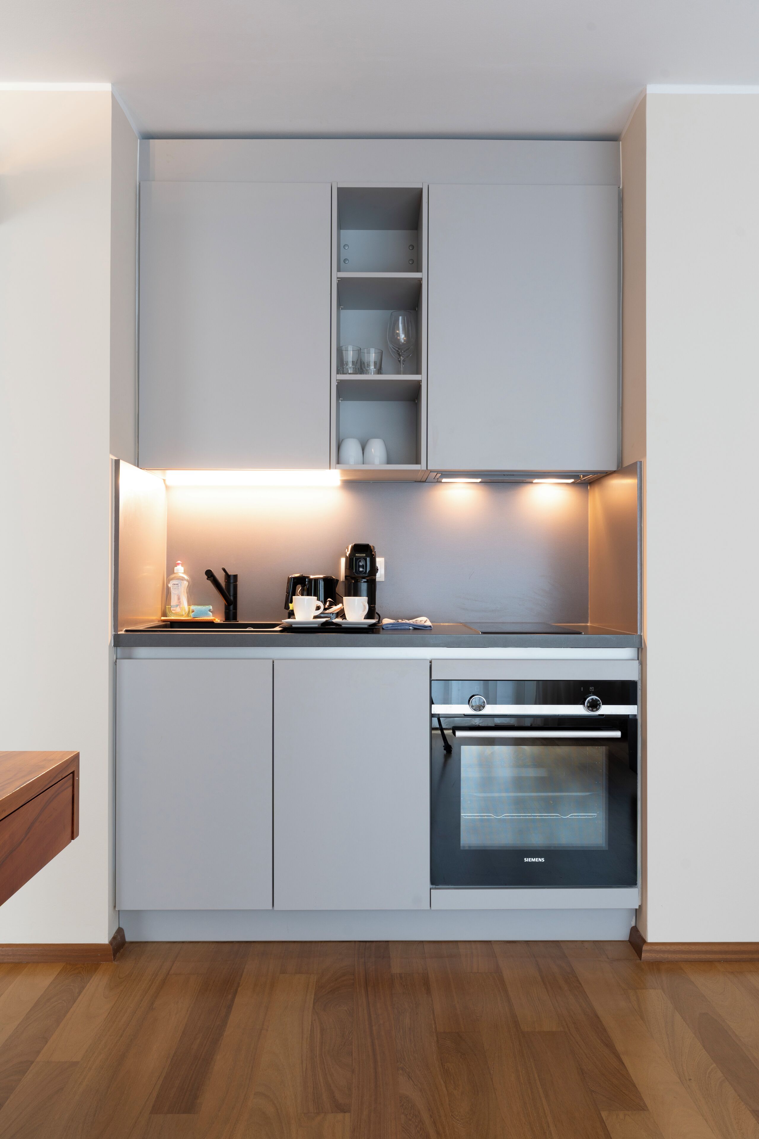 A modern kitchen with built-in appliances, a coffee maker, and a Siemens oven.