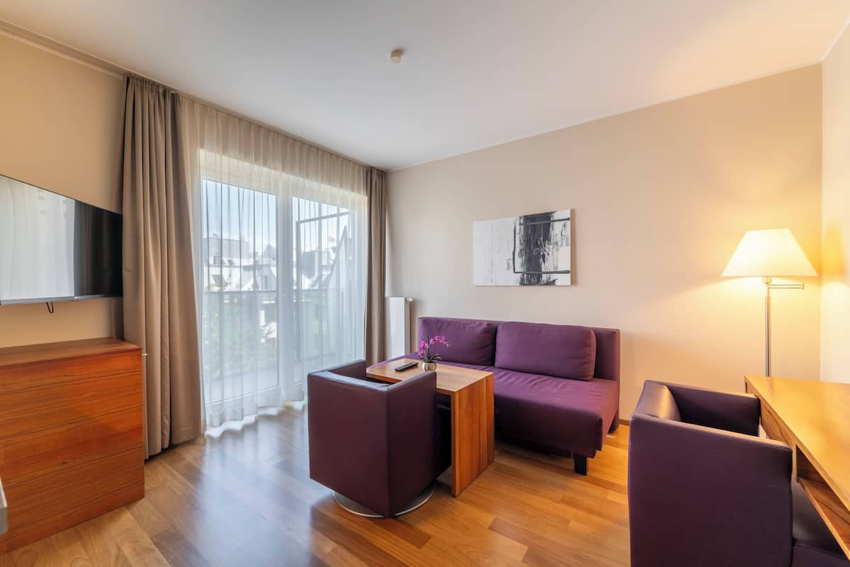 A modern living room with a sofa, a coffee table, a TV, and a lamp.