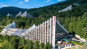 Un hôtel à plusieurs étages, doté de balcons et d’un panneau indiquant la présence d’un spa.