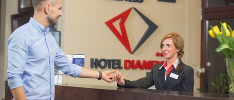 A hotel reception desk with a sign that reads "SPA HOTEL DIAMENT & WELLNESS".