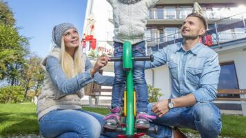 A family interacting with a children's ride at a hotel.