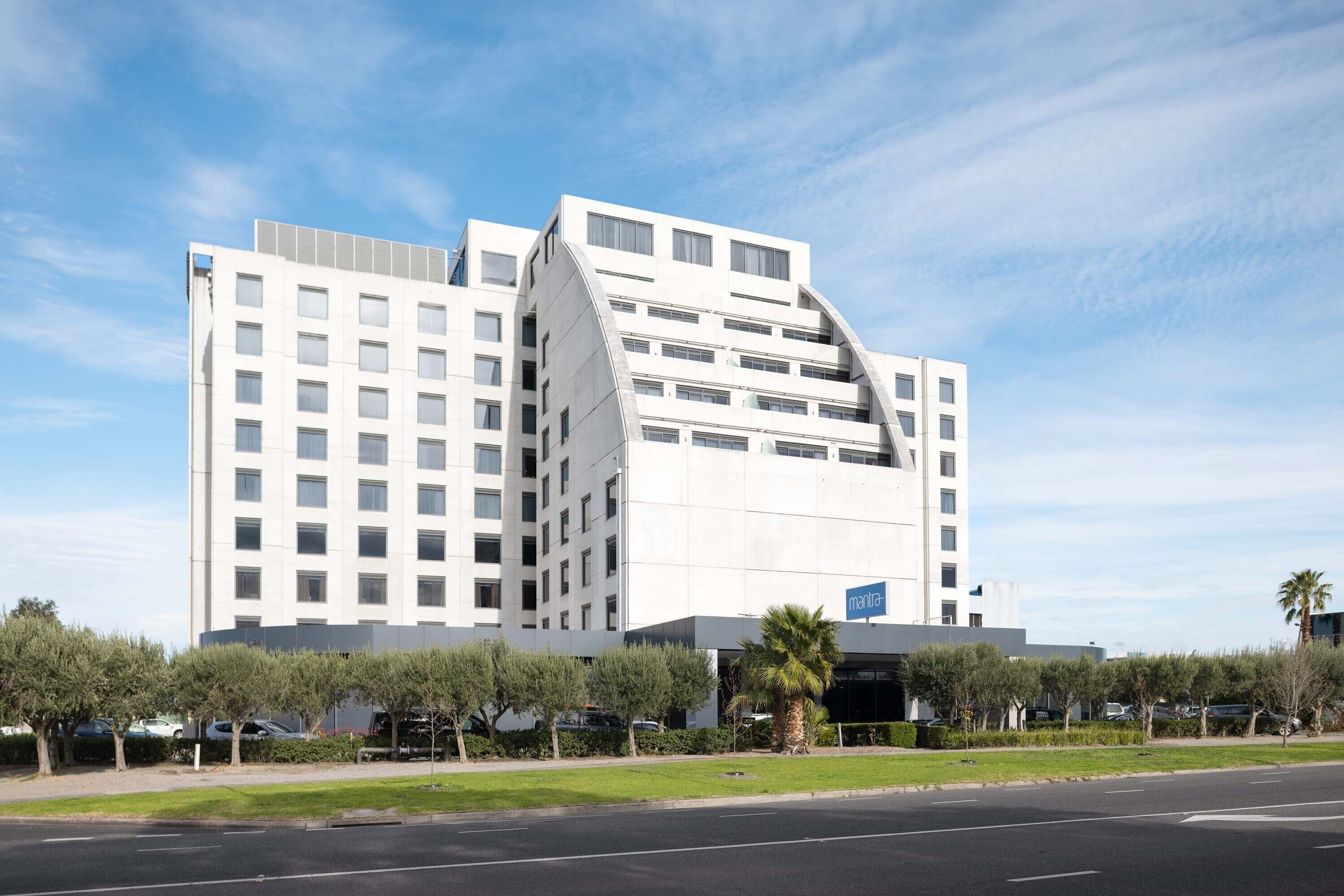 Un hotel moderno con un diseño arquitectónico único, que destaca por su fachada curva y varios pisos.