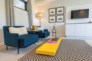 Superior kamer | Woonruimte | Een 40-inch televisie met satellietzenders, een dvd-speler en boeken