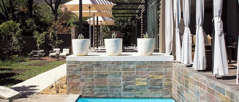 Una piscina al aire libre, sillones reclinables de piscina