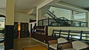 Eine geräumige Lobby mit Treppe, Sitzbereich und Rezeption.