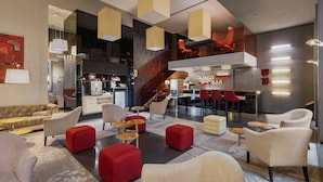 Un espace de détente moderne comprenant des sièges, un escalier et un bar.