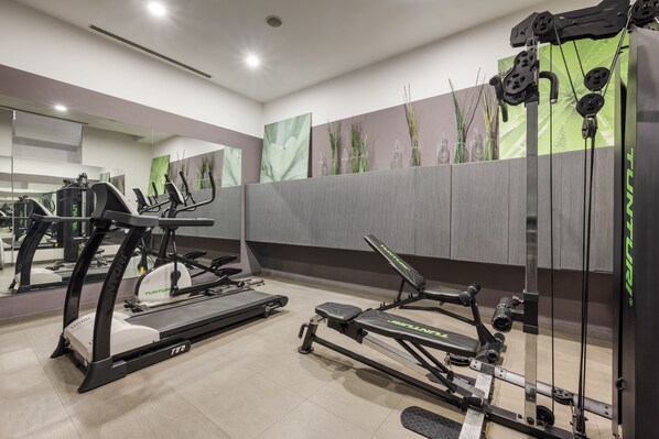 A modern gym with cardio machines, weight benches, and mirrors. - Eurostars Palazzo Zichy (Budapest)