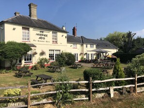 A building named "The Mortimer Arms" with outdoor seating and a garden area. - The Mortimer Arms  (Romsey)