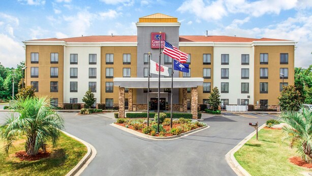 Un hotel con entrada central, varios pisos y una exhibición de banderas.