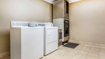 A laundry area with a front-loading washer and dryer, a water dispenser, and a microwave.