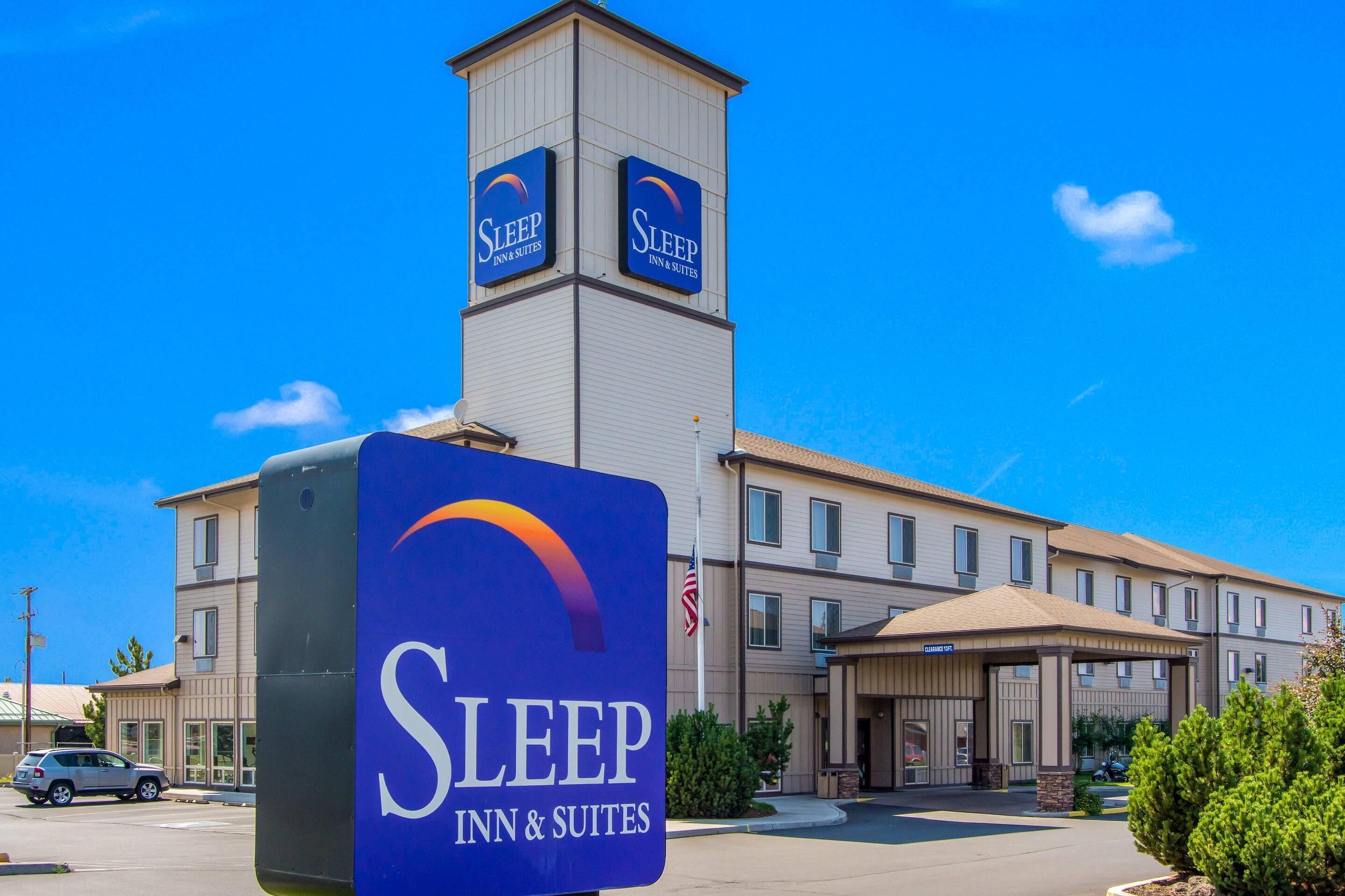 A Sleep Inn & Suites building with a prominent tower and signage.