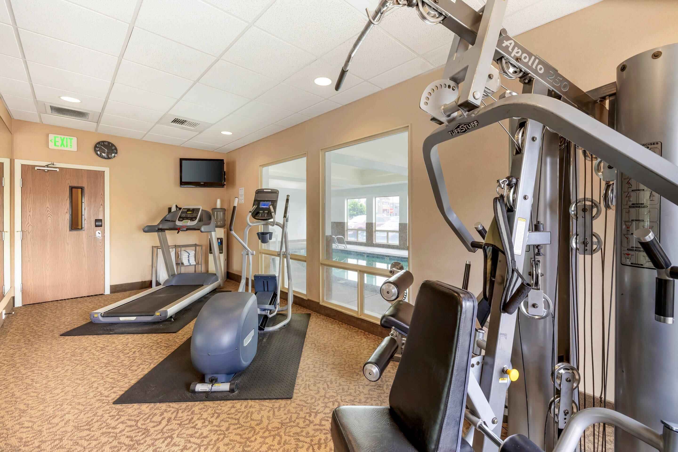 Un gimnasio con cintas de correr, elípticas y máquinas de pesas.