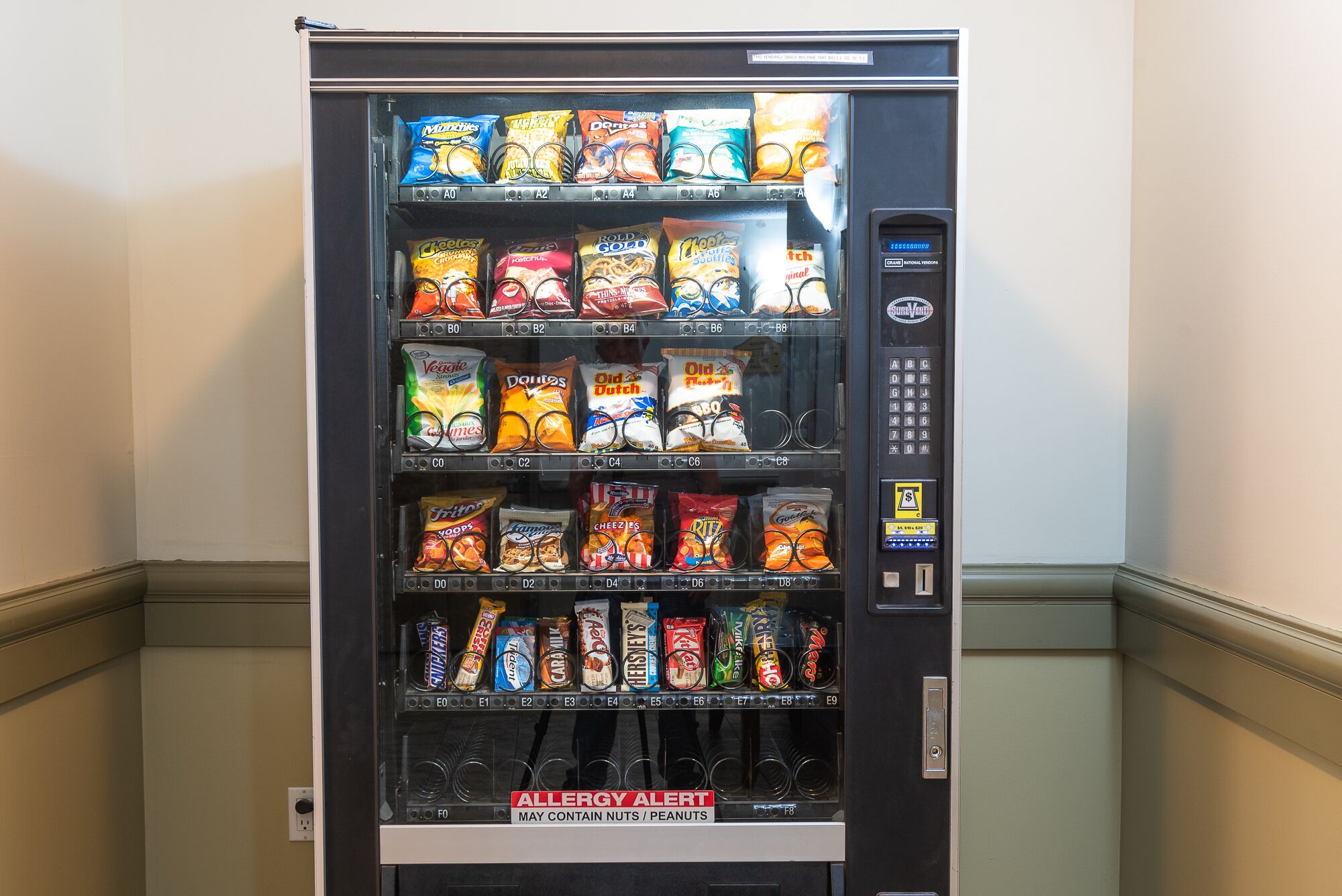 A vending machine stocked with various snacks and candies.