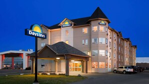 Un hotel Days Inn con un cartel llamativo, varios pisos y un área de estacionamiento.