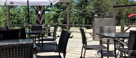 Un espacio al aire libre con patio, mobiliario de mimbre y un paraguas blanco grande.