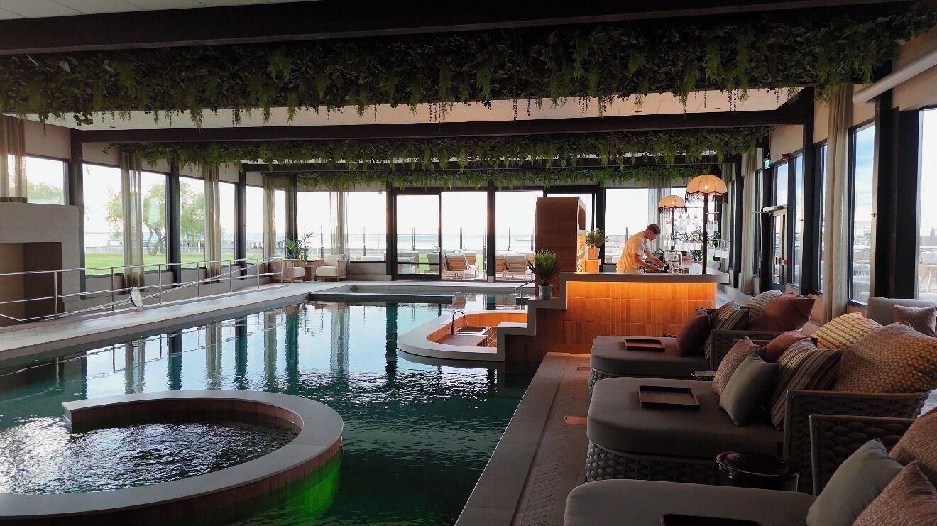 Ein moderner Poolbereich im Innenbereich mit Sitzgelegenheiten und einer Bar.