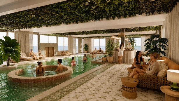Un área de piscina interior con asientos de sala y un mostrador de recepción.