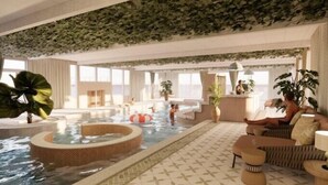 Un espacio interior amplio con un jacuzzi central, zonas de estar y un mostrador de recepción.