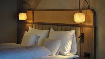 A bed with white linens and a headboard with a textured pattern.