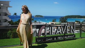 A woman standing in front of a sign for Sky Bar & Restaurant at Sugar Palm. - Sugar Palm Grand Hillside (Karon)