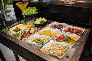 Un bufé con diversos alimentos, como pasta, ensaladas y verduras.