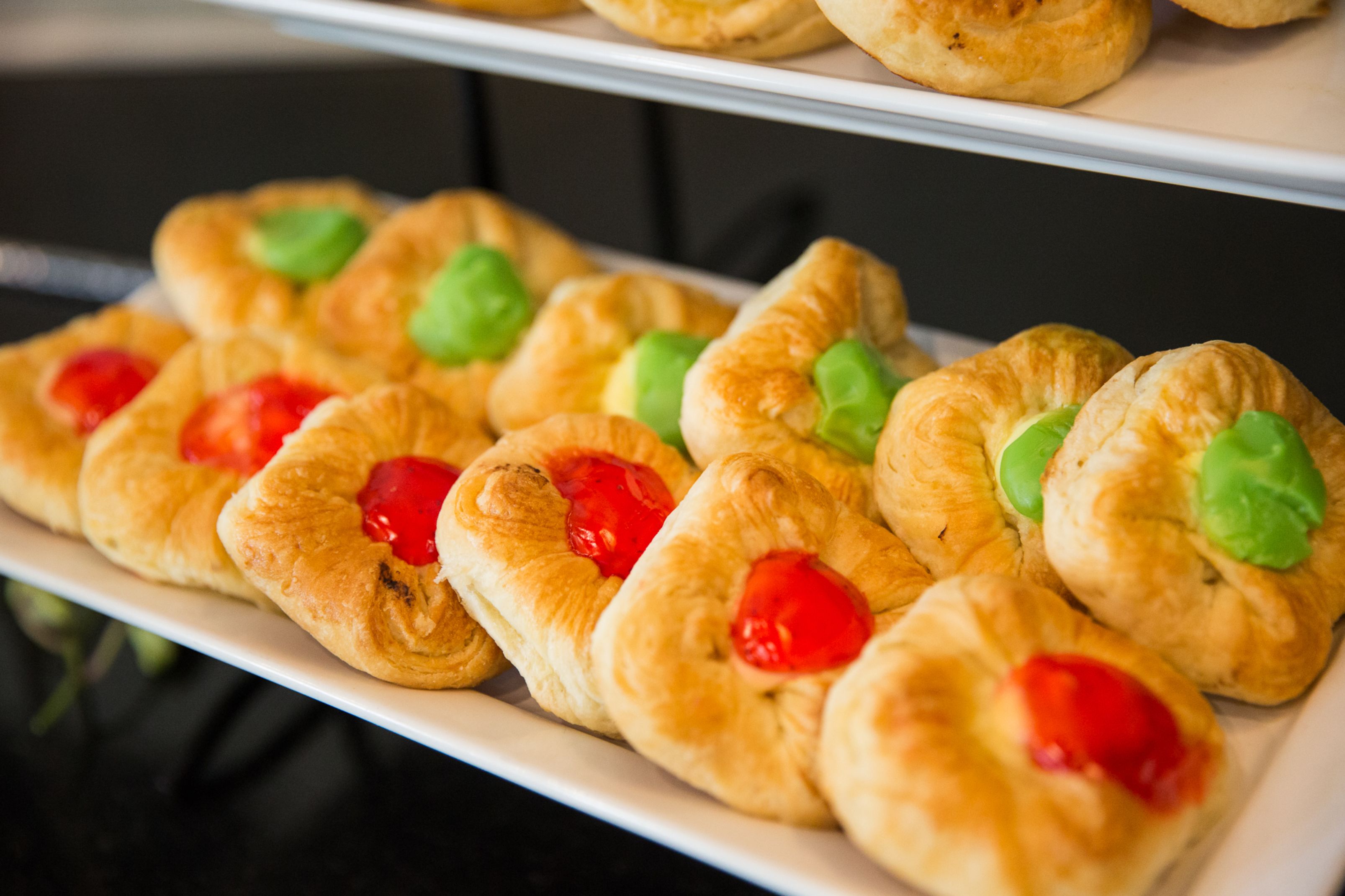 Une étagère où sont exposées des pâtisseries garnies de fruits.