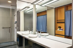 A modern bathroom with two sinks, a large mirror, and a shower area. - Aloft by Marriott Denver Airport at Gateway Park (Aurora)