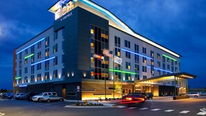 A modern hotel with a prominent 'HOTEL' sign, multiple floors, and a covered entrance area. - Aloft by Marriott Denver Airport at Gateway Park (Aurora)