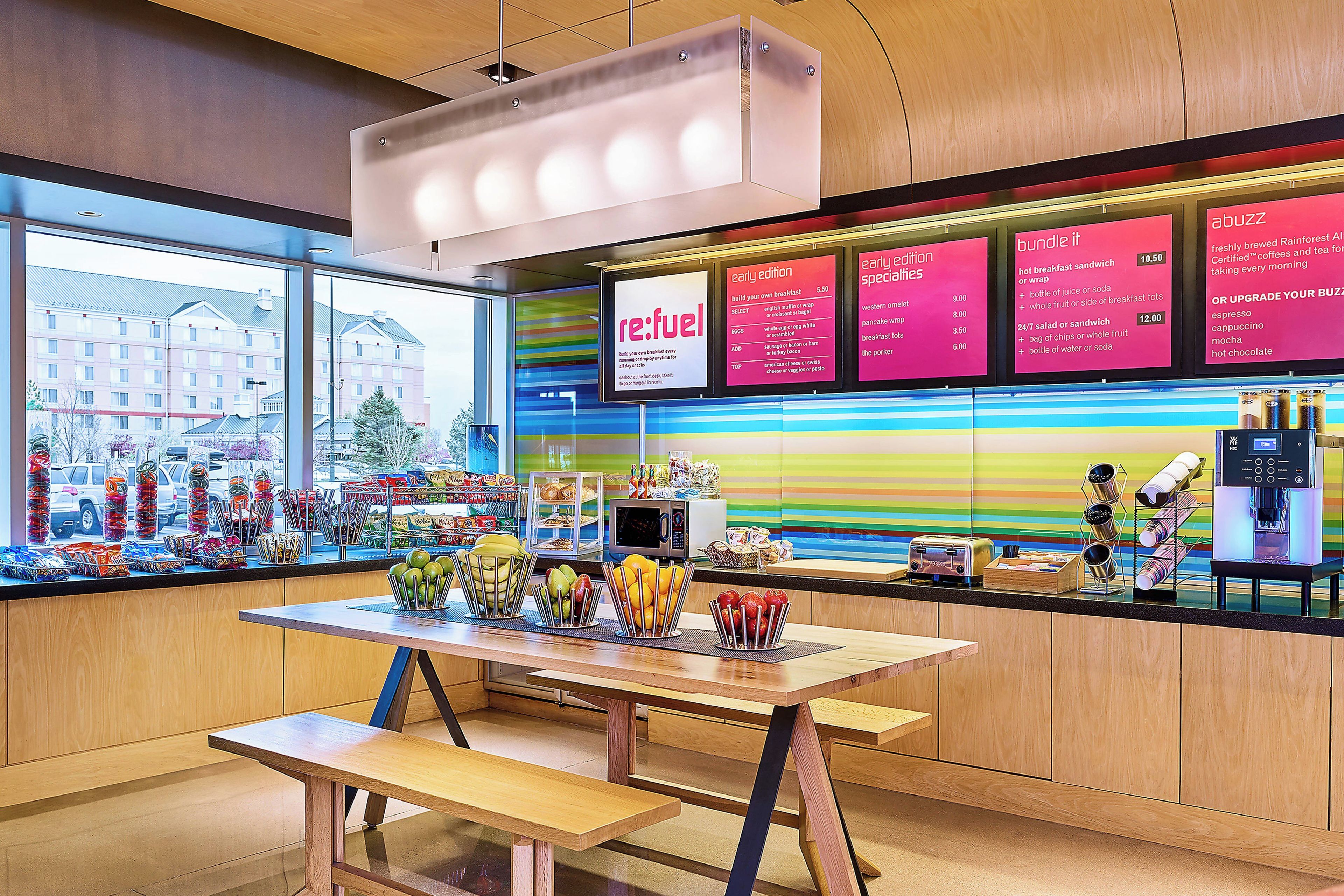 A breakfast area with a table, chairs, and a menu board.