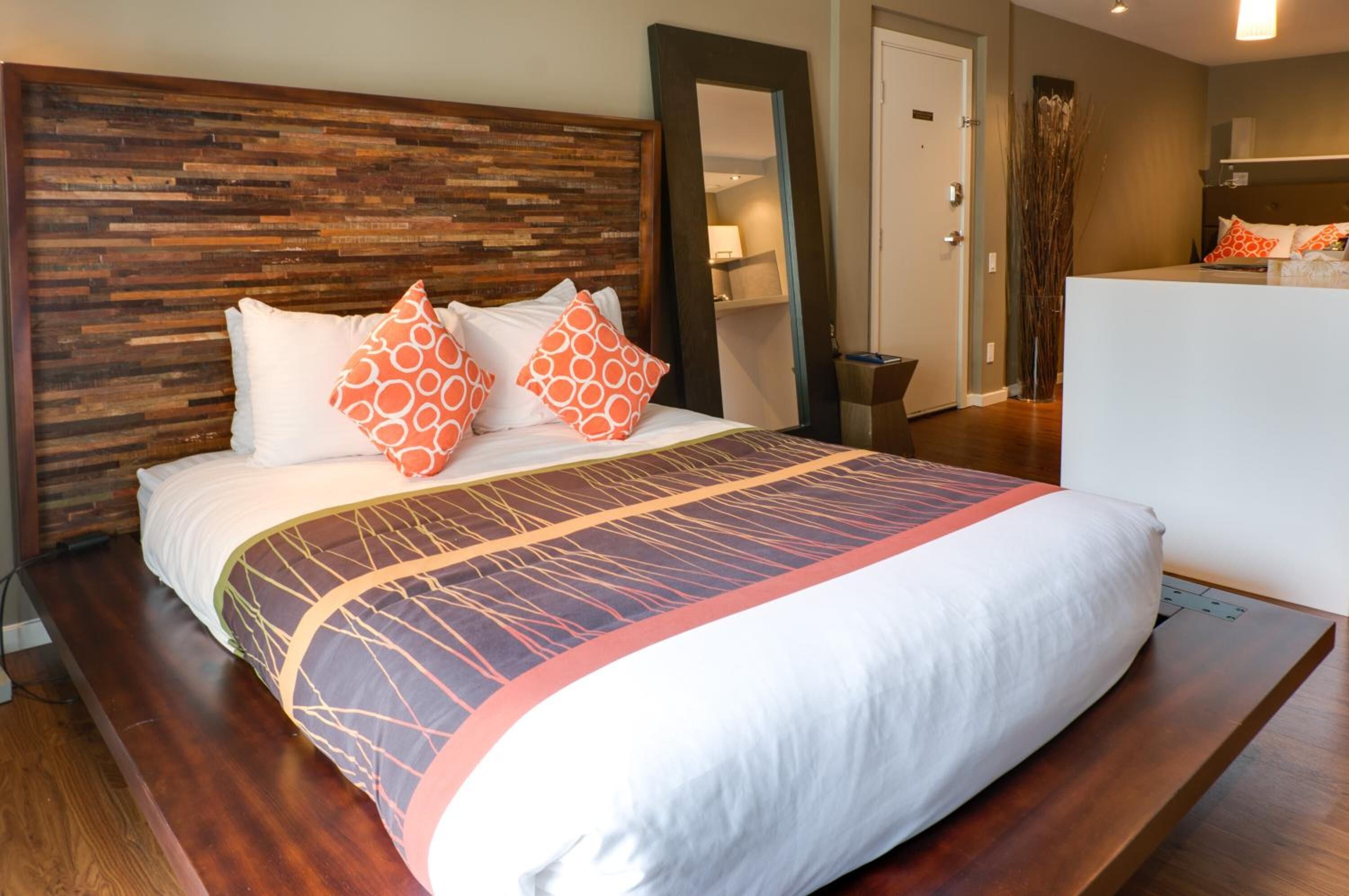 A neatly made bed with patterned bedding, a wooden headboard, and a bedside table.