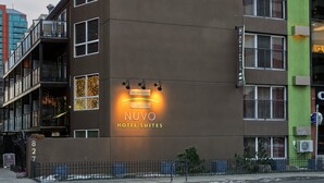 A modern hotel building with a sign reading "NUVO HOTEL SUITES". - Nuvo Hotel & Suites (Calgary)