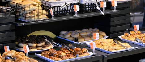 A buffet with various baked goods and pastries.