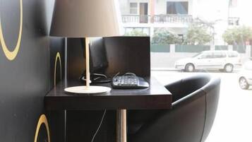 Ein Büro mit Ecklage, ausgestattet mit Schreibtisch, Stuhl, Lampe und Blick auf die Straße.
