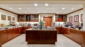 A spacious kitchen with a central island, wooden cabinets, and various kitchen appliances.